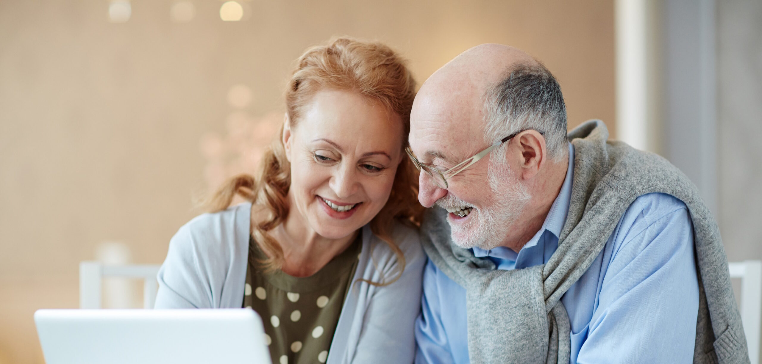 elderly couple looking at laptop